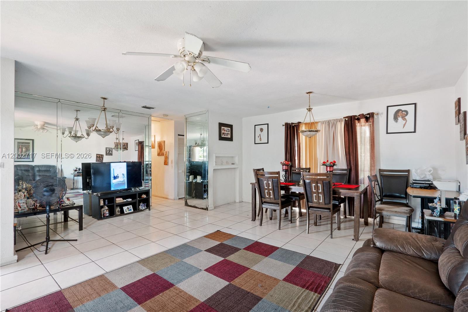 A living and dining area features white tile floors, a checkered rug, and mirrored walls — 11960 SW 176th St, Miami FL 33177, MIAMI, FL