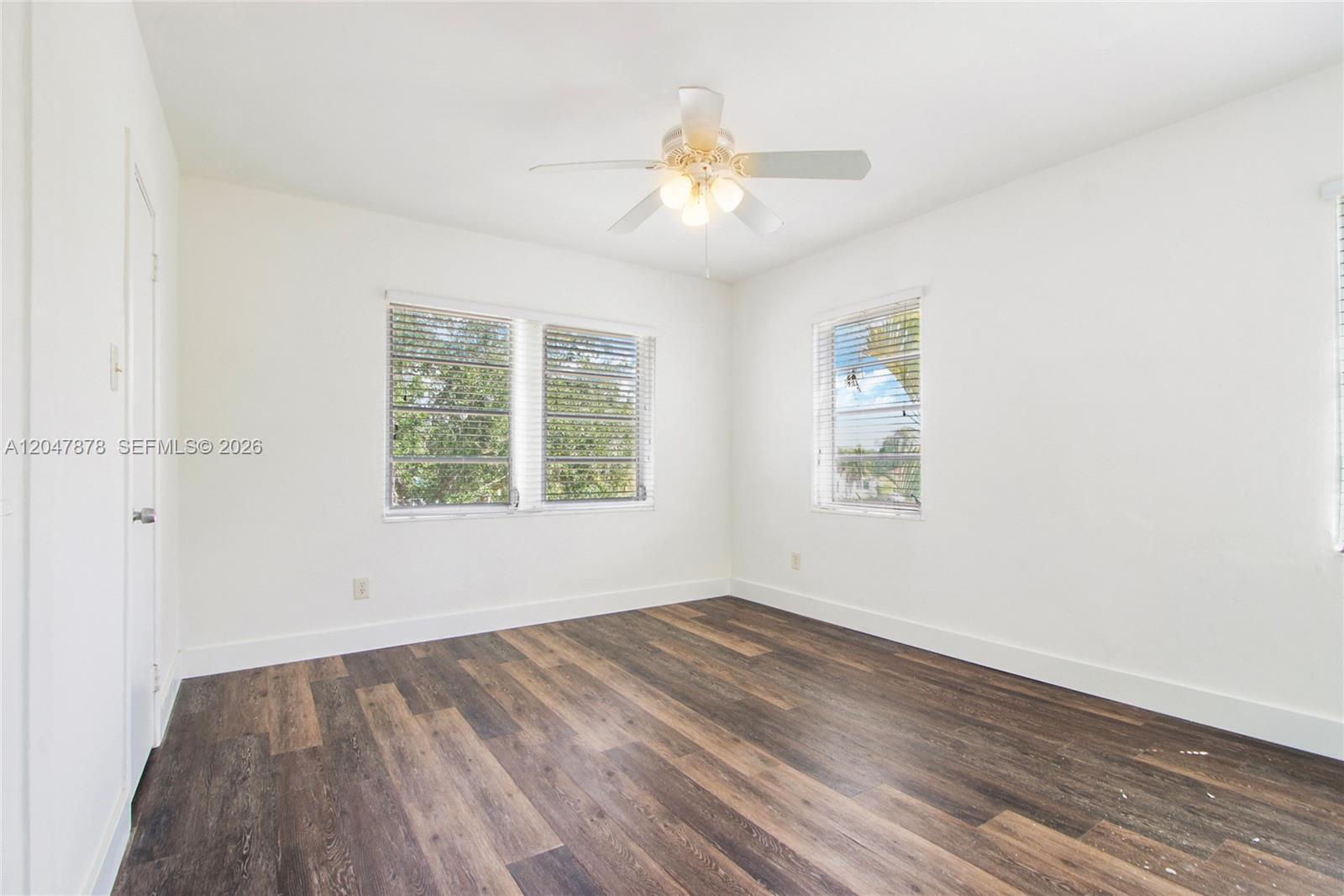 An empty bedroom features white walls, dark wood-look flooring, and a ceiling fan — 2352 SW 26th Ln, Miami FL 33133, MIAMI, FL