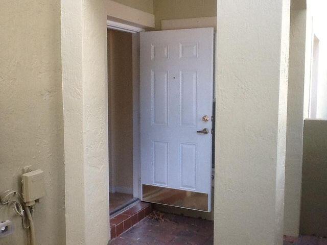 A white six-panel door with a kick plate opens into a tiled entryway — 101 Lake Monterey Circle, Boynton Beach FL 33426, BOYNTON BEACH, FL