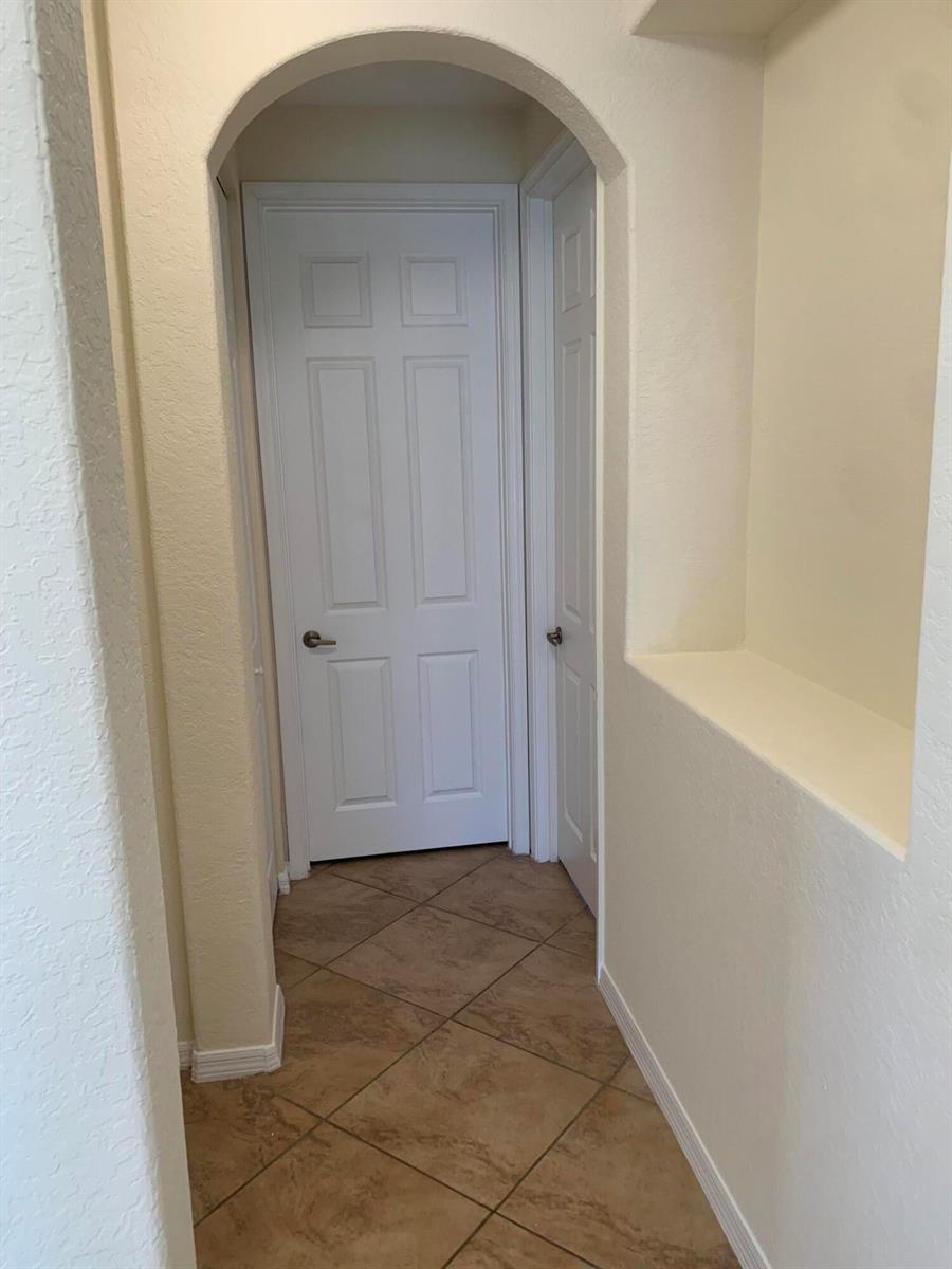 A tiled hallway features an arched entryway leading to two white interior doors — 101 Lake Monterey Circle, Boynton Beach FL 33426, BOYNTON BEACH, FL
