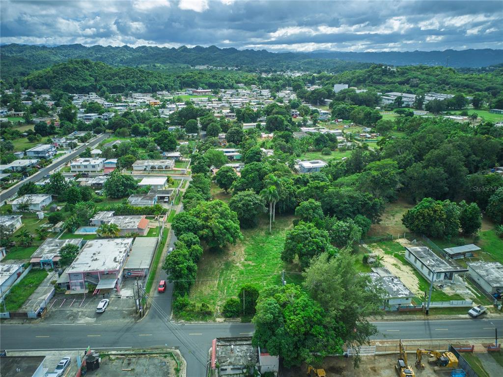 An aerial view shows a vacant lot surrounded by residential houses and lush green trees — SR 662 SR 662 KM 1.9 SEC LOS LLANOS, ARECIBO, PR