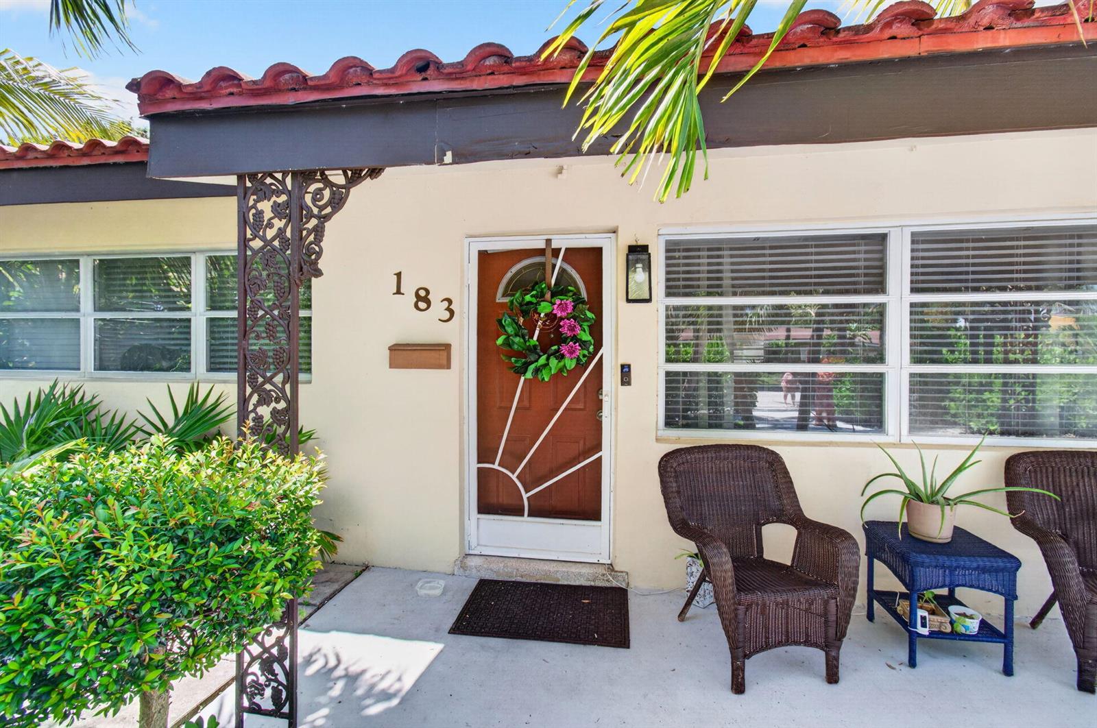 The exterior of a house features a front porch with wicker chairs and a door — 183 Harvard Drive, Lake Worth FL 33460, LAKE WORTH, FL