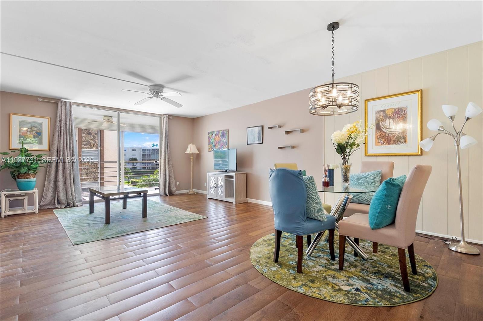 A living and dining area features wood flooring, a glass-topped table, and a balcony view — 324 SE 10th St # 203, Dania Beach FL 33004, DANIA BEACH, FL