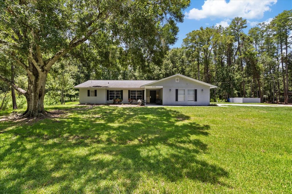 A single-story house with a gray exterior and black shutters sits on a grassy lot — 346 RANCH ROAD, TARPON SPRINGS, FL