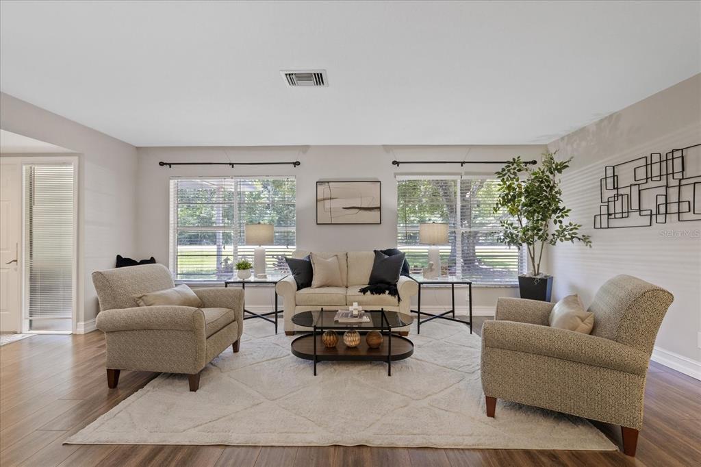 A living room features a sofa, two armchairs, a coffee table, and large windows — 346 RANCH ROAD, TARPON SPRINGS, FL