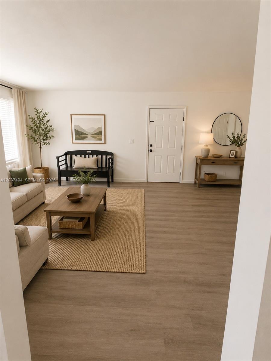 A living room features light wood flooring, a neutral area rug, and a white door — 2812 NW 55th Ave # 2A, Lauderhill FL 33313, LAUDERHILL, FL