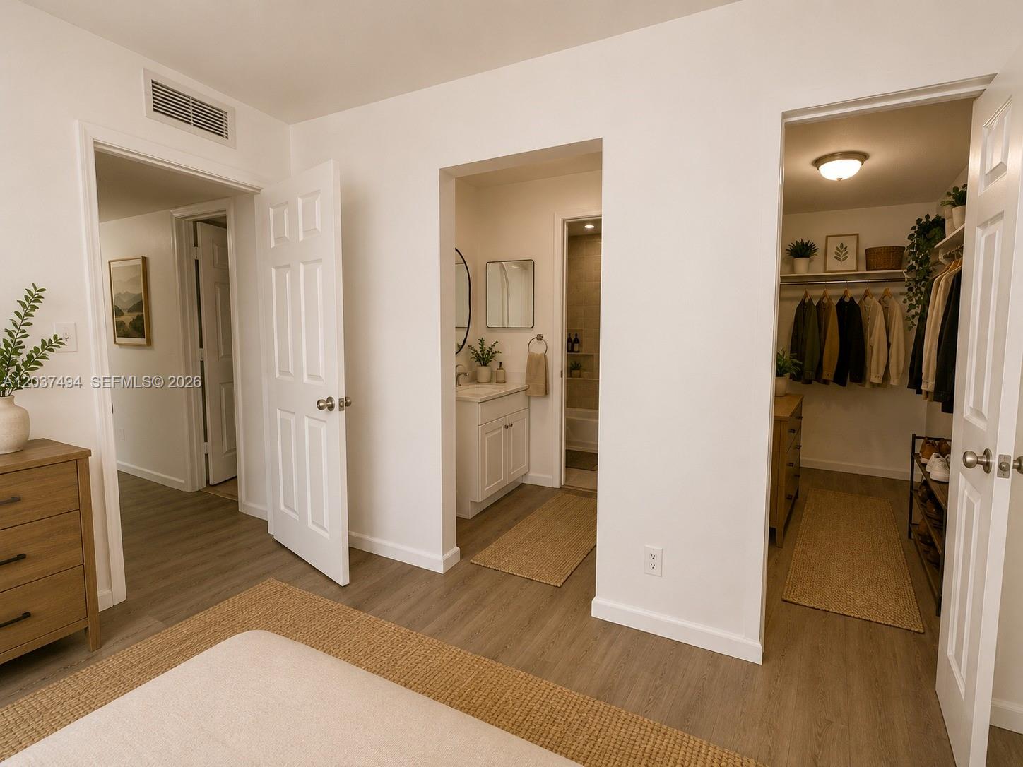 A bedroom features light wood-look flooring, a walk-in closet, and an attached bathroom — 2812 NW 55th Ave # 2A, Lauderhill FL 33313, LAUDERHILL, FL