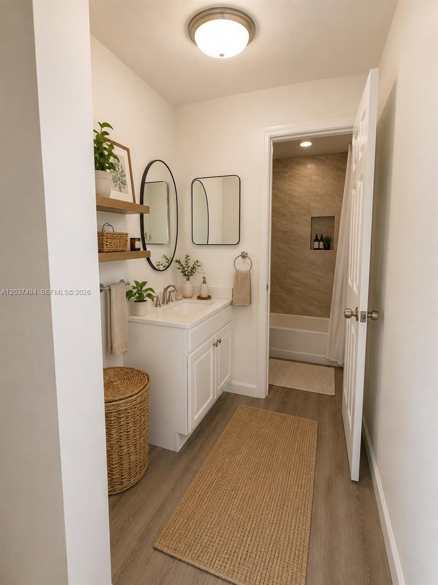A bathroom features a white vanity, two mirrors, open shelving, and a separate tub area — 2812 NW 55th Ave # 2A, Lauderhill FL 33313, LAUDERHILL, FL