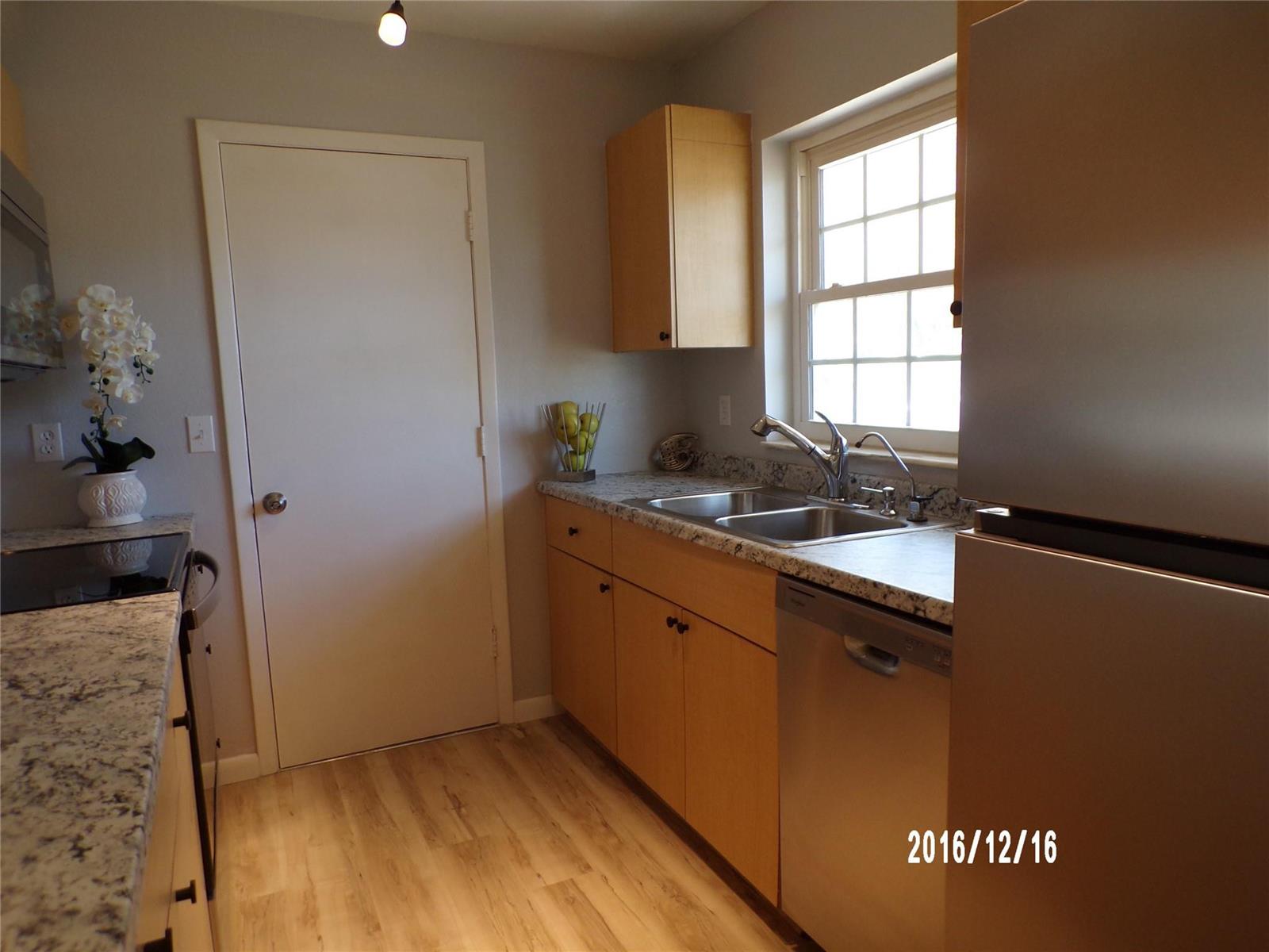 A kitchen features light wood cabinets, granite countertops, stainless steel appliances, and a window — 2265 14th Avenue SW, Vero Beach FL 32962, VERO BEACH, FL