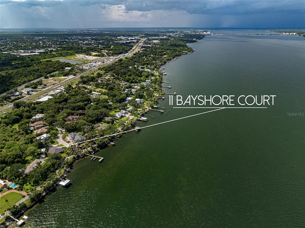An aerial view shows a waterfront residential property along a large body of water — 11 BAYSHORE COURT, ROCKLEDGE, FL