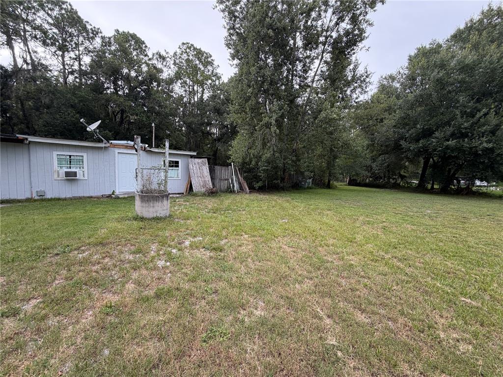 A light-colored house with a satellite dish and a concrete well in the backyard — 6900 ANGUS VALLEY DRIVE, WESLEY CHAPEL, FL