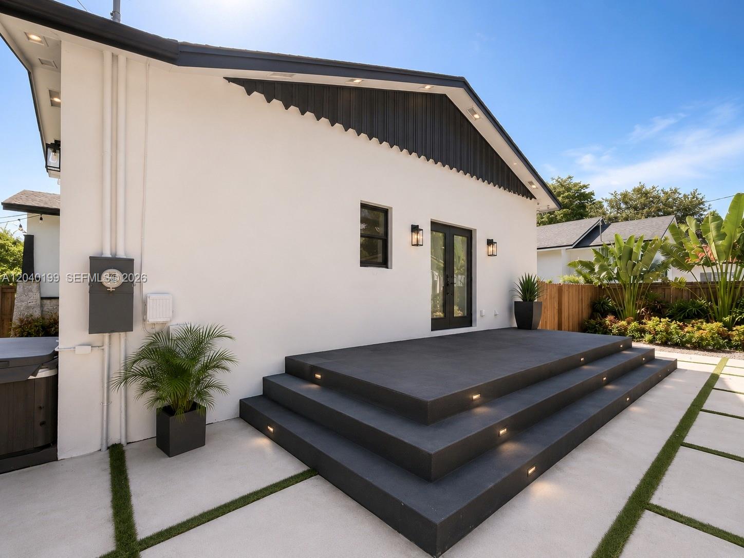 A white house exterior features a dark gray tiered deck with integrated step lighting — 4605 N Miami Ave, Miami FL 33127, MIAMI, FL