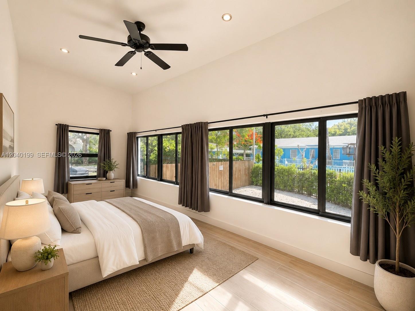 A modern bedroom features a vaulted ceiling, large windows with dark curtains, and light flooring — 4605 N Miami Ave, Miami FL 33127, MIAMI, FL