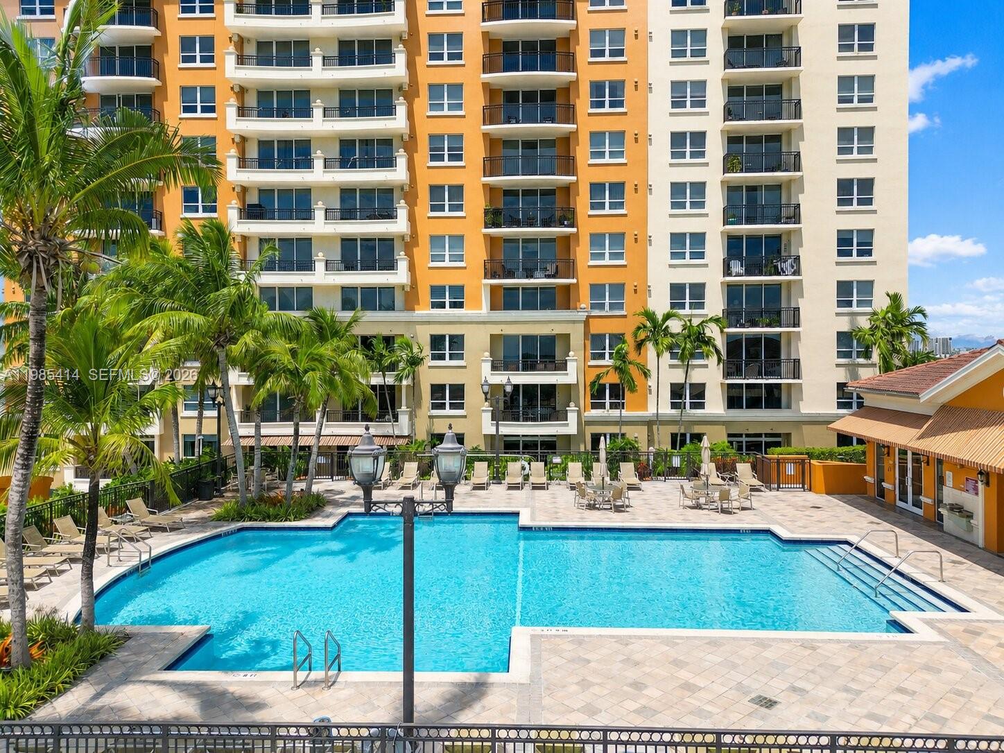 A swimming pool sits on a paved deck in front of a multi-story apartment building — 3232 SW 22nd Ter # 1609, Miami FL 33145, MIAMI, FL