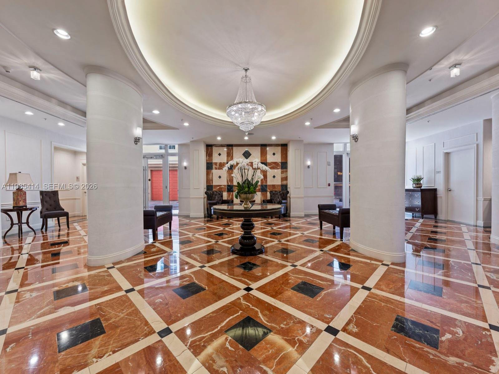 A formal lobby features a crystal chandelier, marble floors, and two large white columns — 3232 SW 22nd Ter # 1609, Miami FL 33145, MIAMI, FL