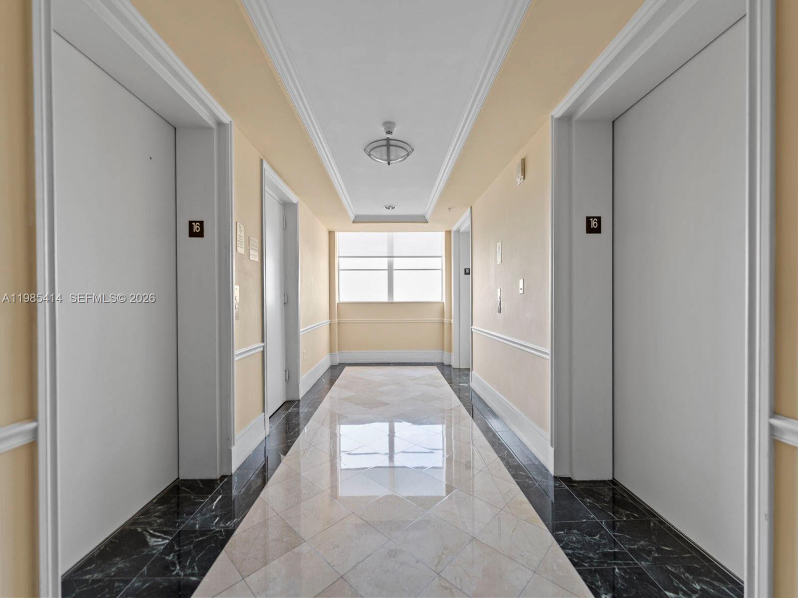 A hallway features light-colored walls, a tiled floor with a black border, and two elevators — 3232 SW 22nd Ter # 1609, Miami FL 33145, MIAMI, FL