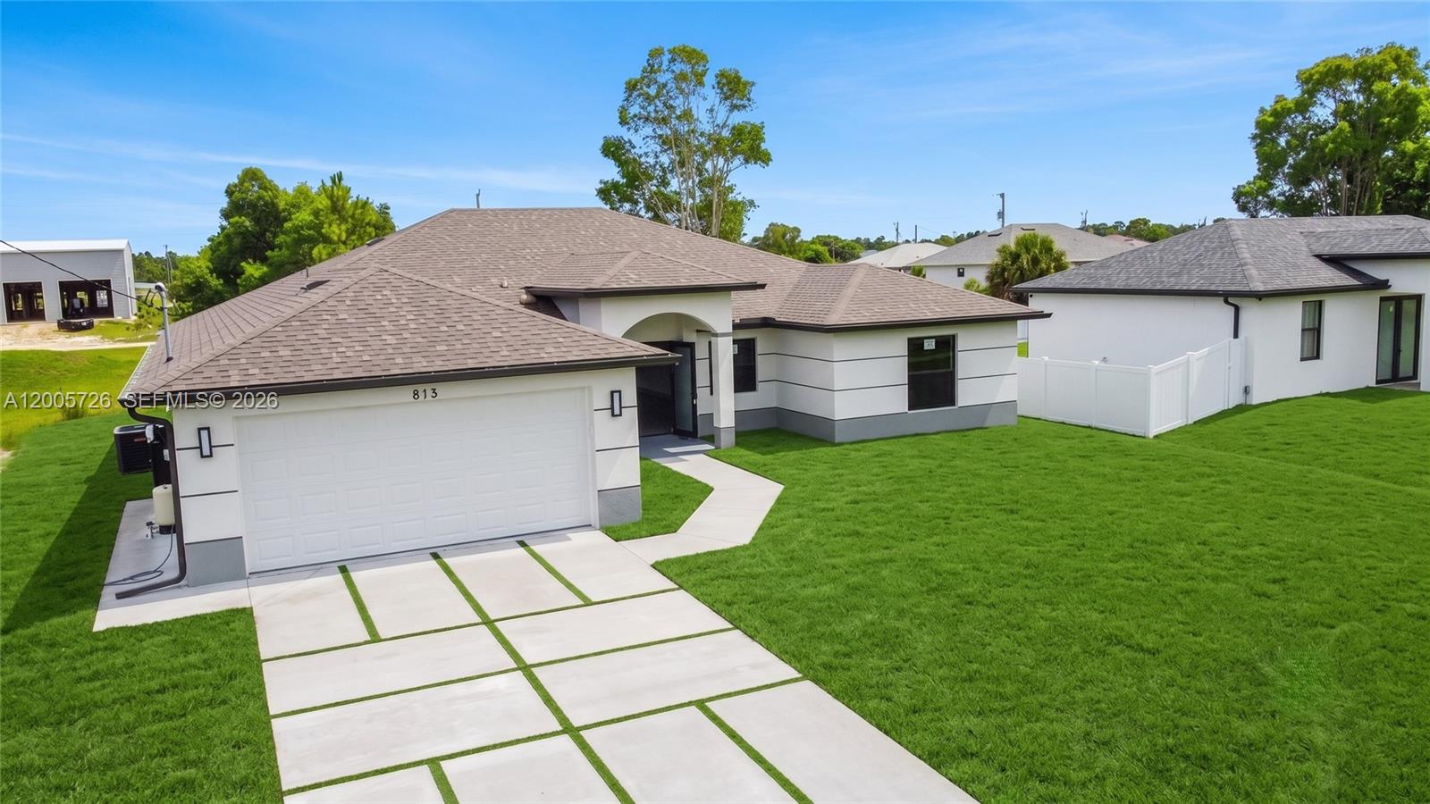 A single-story house with a white exterior, gray roof, and a concrete paver driveway — 813 Bell Blvd S, Lehigh Acres FL 33974, LEHIGH ACRES, FL