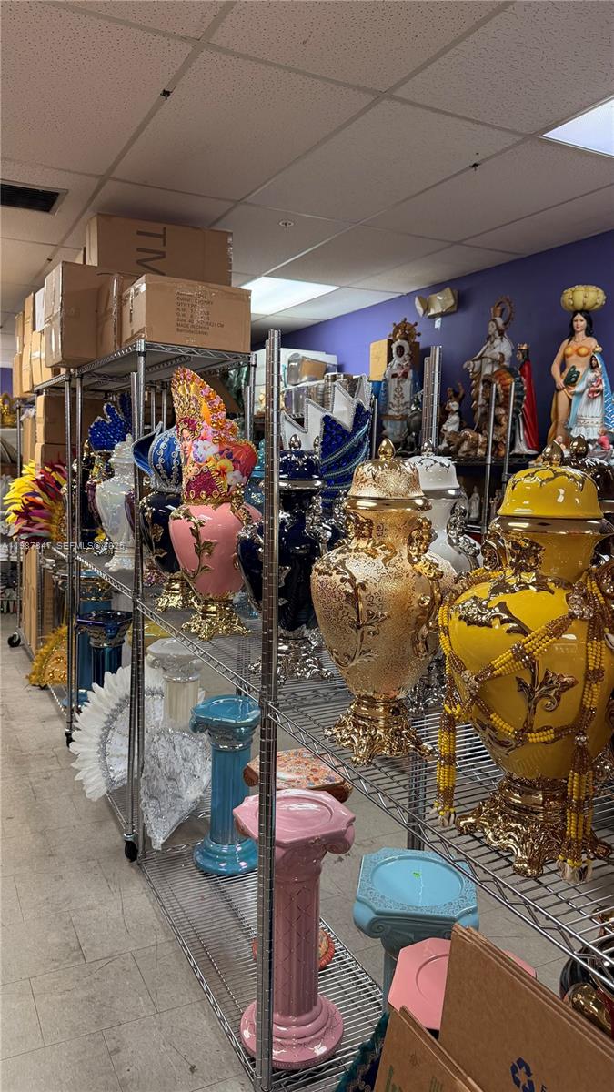 A storage room features metal shelving units filled with decorative ceramic vases and religious statues — 1580 W 37 St, Hialeah FL 33012, HIALEAH, FL