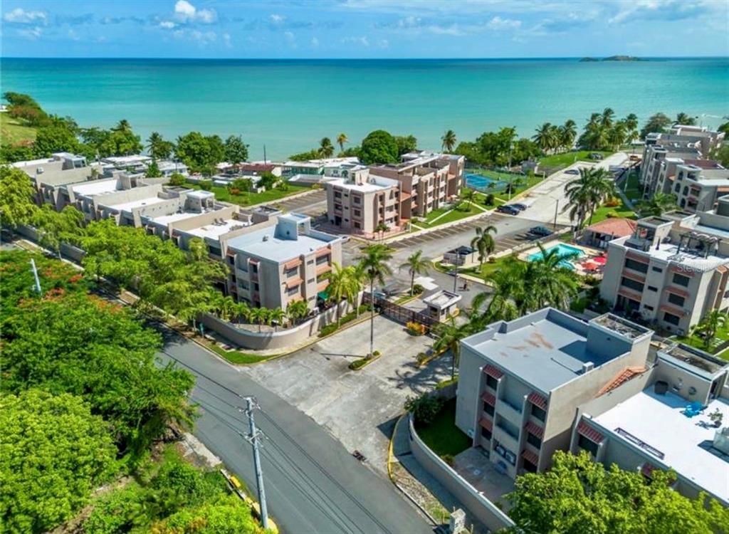 An aerial view of a coastal apartment complex with a swimming pool and parking area — CARR 3 KM 66.7 CALA DE HUCARES UNIT C210, NAGUABO, PR