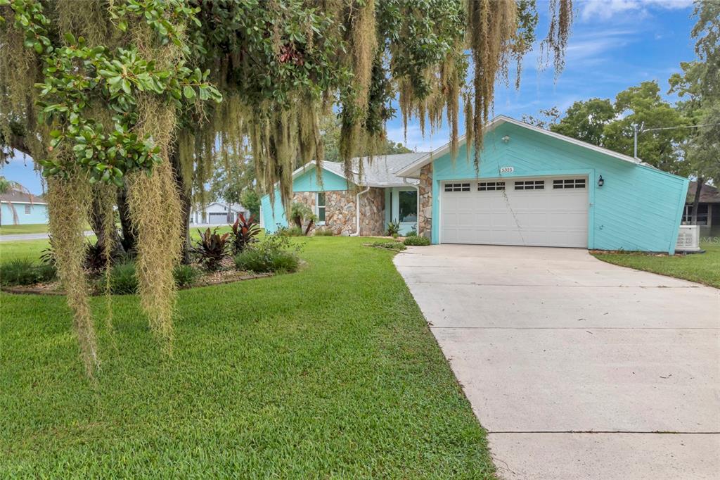 A light blue single-story house with a stone facade and a two-car garage — 5325 ABAGAIL DRIVE, SPRING HILL, FL