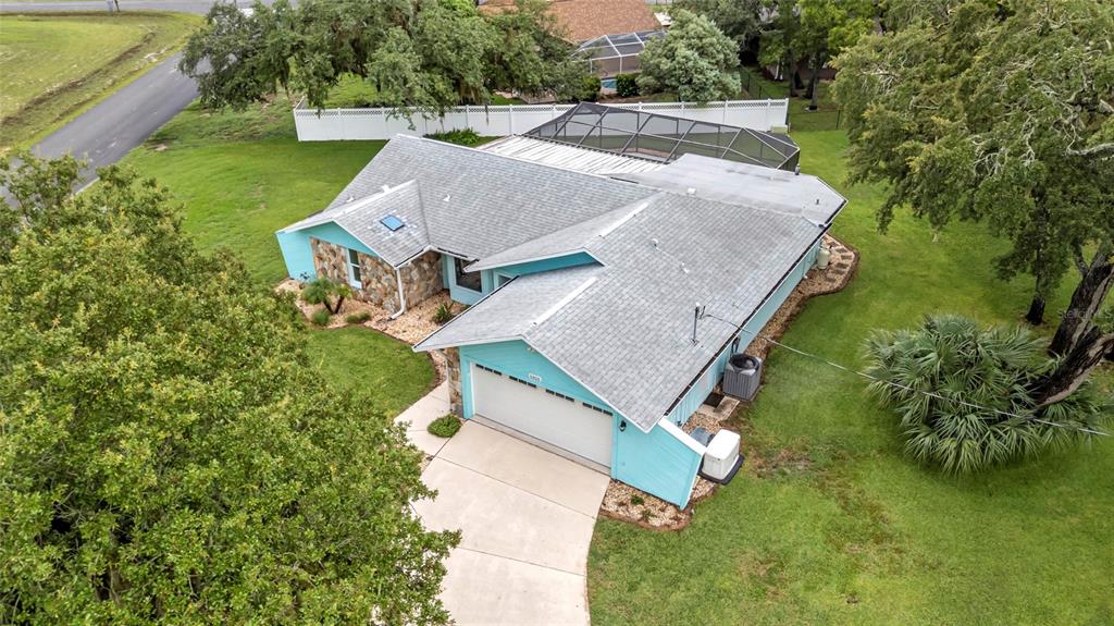 An aerial view of a light blue house with a gray roof and screened pool enclosure — 5325 ABAGAIL DRIVE, SPRING HILL, FL
