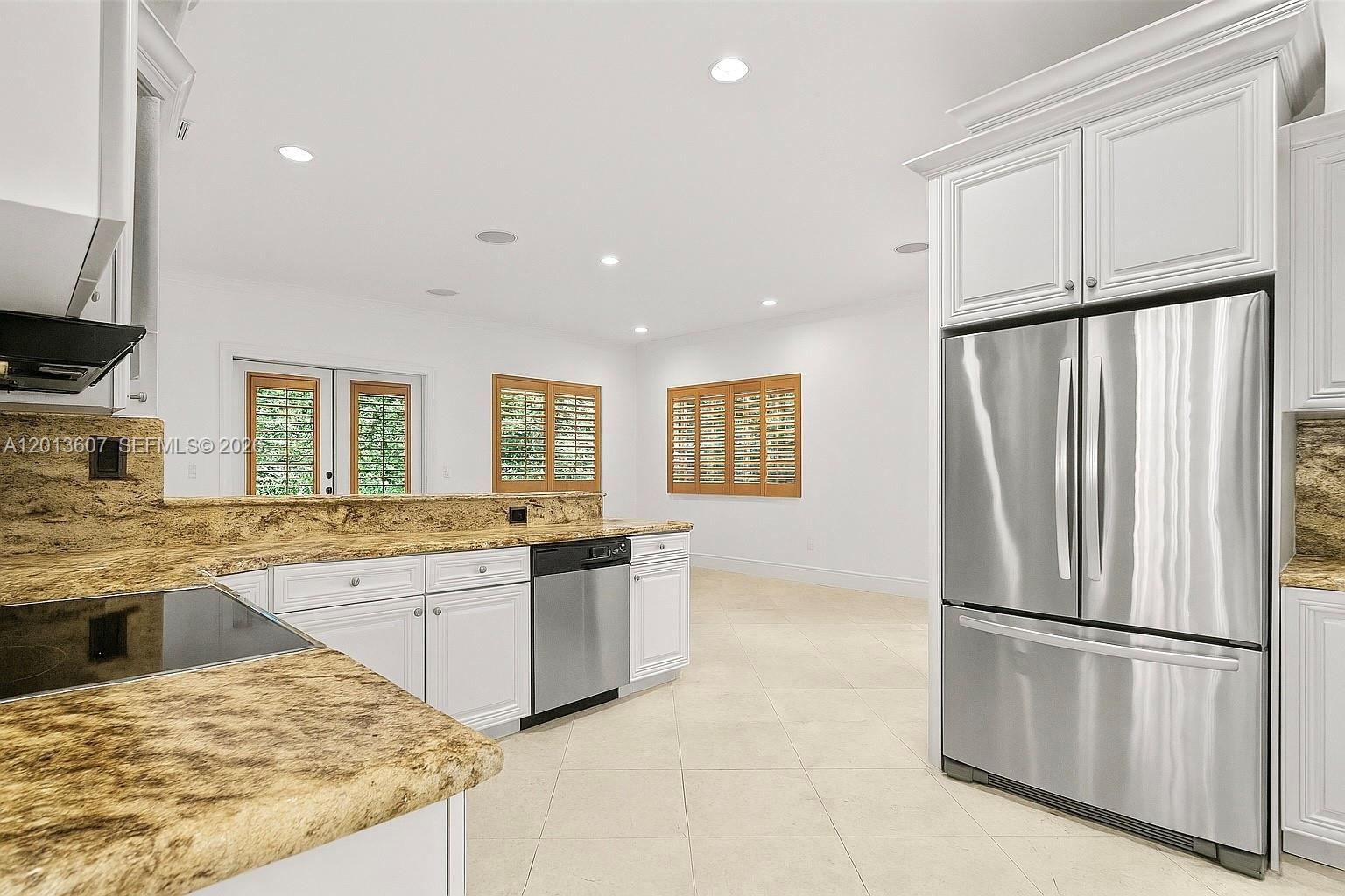 A kitchen features white cabinets, granite countertops, stainless steel appliances, and tile flooring — 16763 NW 77th Path, Miami Lakes FL 33016, MIAMI LAKES, FL