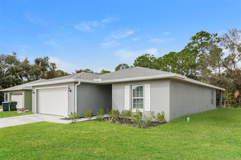 A gray, single-story house with a white garage door and white window shutters — 3673 SHALIMAR TERRACE, NORTH PORT, FL