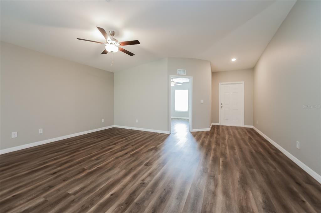 An empty room with light gray walls, wood-look flooring, and a ceiling fan — 3673 SHALIMAR TERRACE, NORTH PORT, FL
