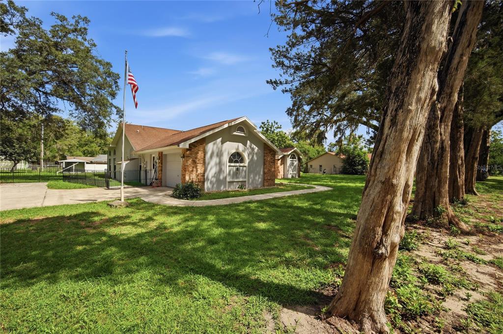 A single-story house with a brick facade, a garage, and a flag pole outside — 483 LINCOLN AVENUE, MASARYKTOWN, FL