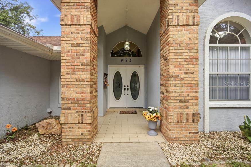 The front entrance features a double door with glass inserts between two brick pillars — 483 LINCOLN AVENUE, MASARYKTOWN, FL
