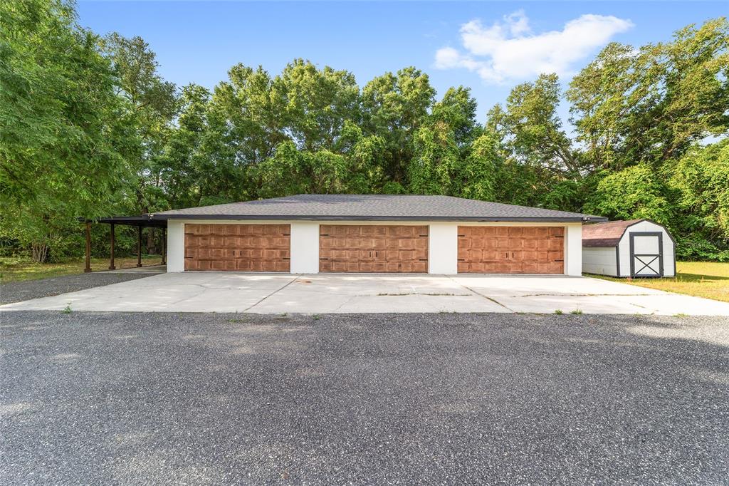 A single-story house with white siding, a dark metal roof, and a covered front porch — 10575 SW 27TH AVENUE, OCALA, FL