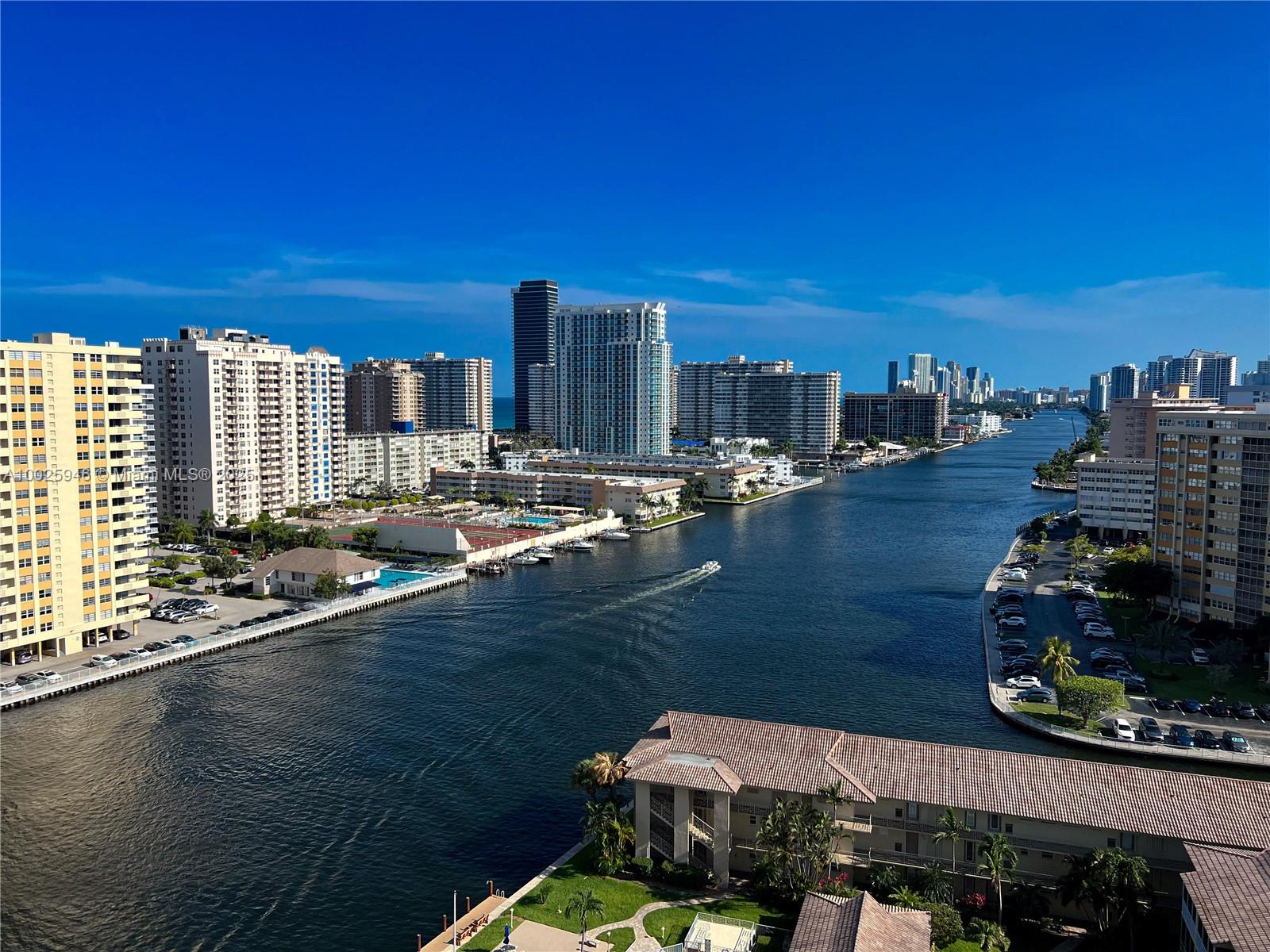 An elevated view of a canal lined with high-rise apartment buildings and parked cars — 2602 E HALLANDALE BEACH BLVD # 1605, Hallandale Beach FL 33009, HALLANDALE BEACH, FL