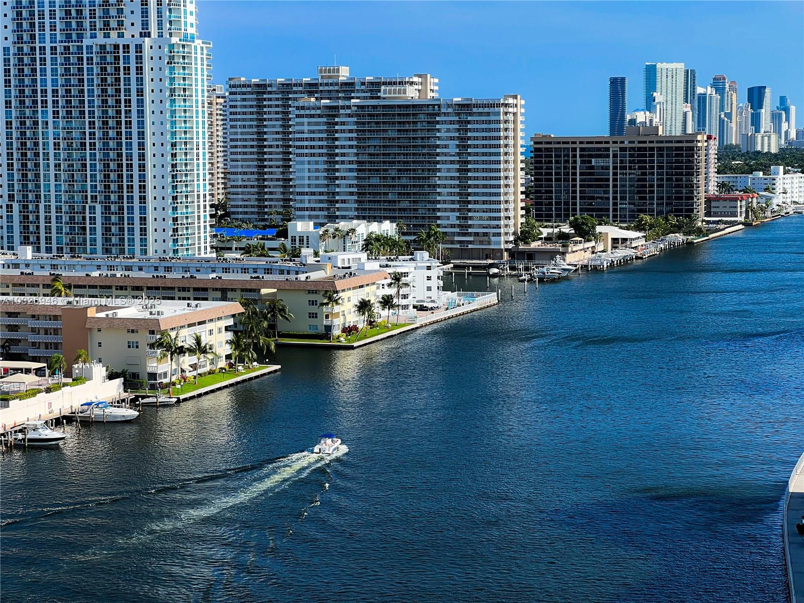 An aerial view shows a canal with a boat, surrounded by high-rise residential buildings — 2602 E HALLANDALE BEACH BLVD # 1605, Hallandale Beach FL 33009, HALLANDALE BEACH, FL