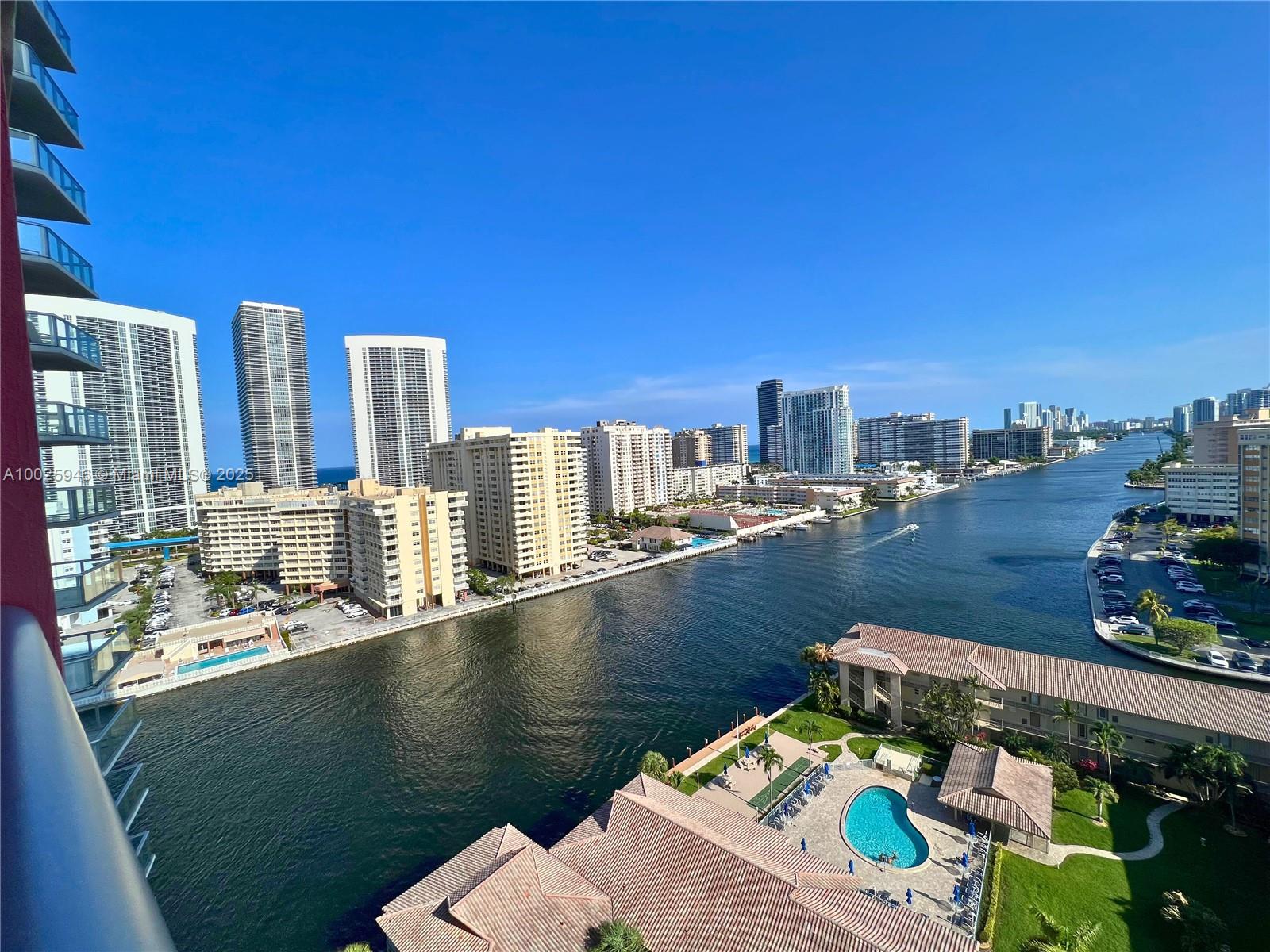 An elevated view shows a waterway lined with high-rise apartment buildings and a swimming pool — 2602 E HALLANDALE BEACH BLVD # 1605, Hallandale Beach FL 33009, HALLANDALE BEACH, FL
