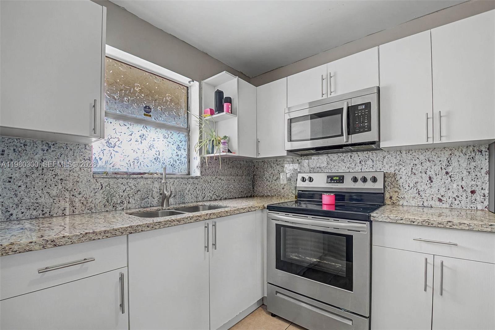 A kitchen features white cabinets, stainless steel appliances, and speckled granite countertops — 6525 W 26th Dr # 37, Hialeah FL 33016, HIALEAH, FL