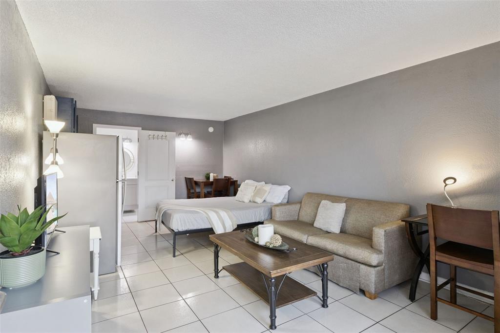 A studio apartment featuring tile floors, a bed, a sofa, and a small dining area — 43420 HIGHWAY 27 UNIT 464, DAVENPORT, FL