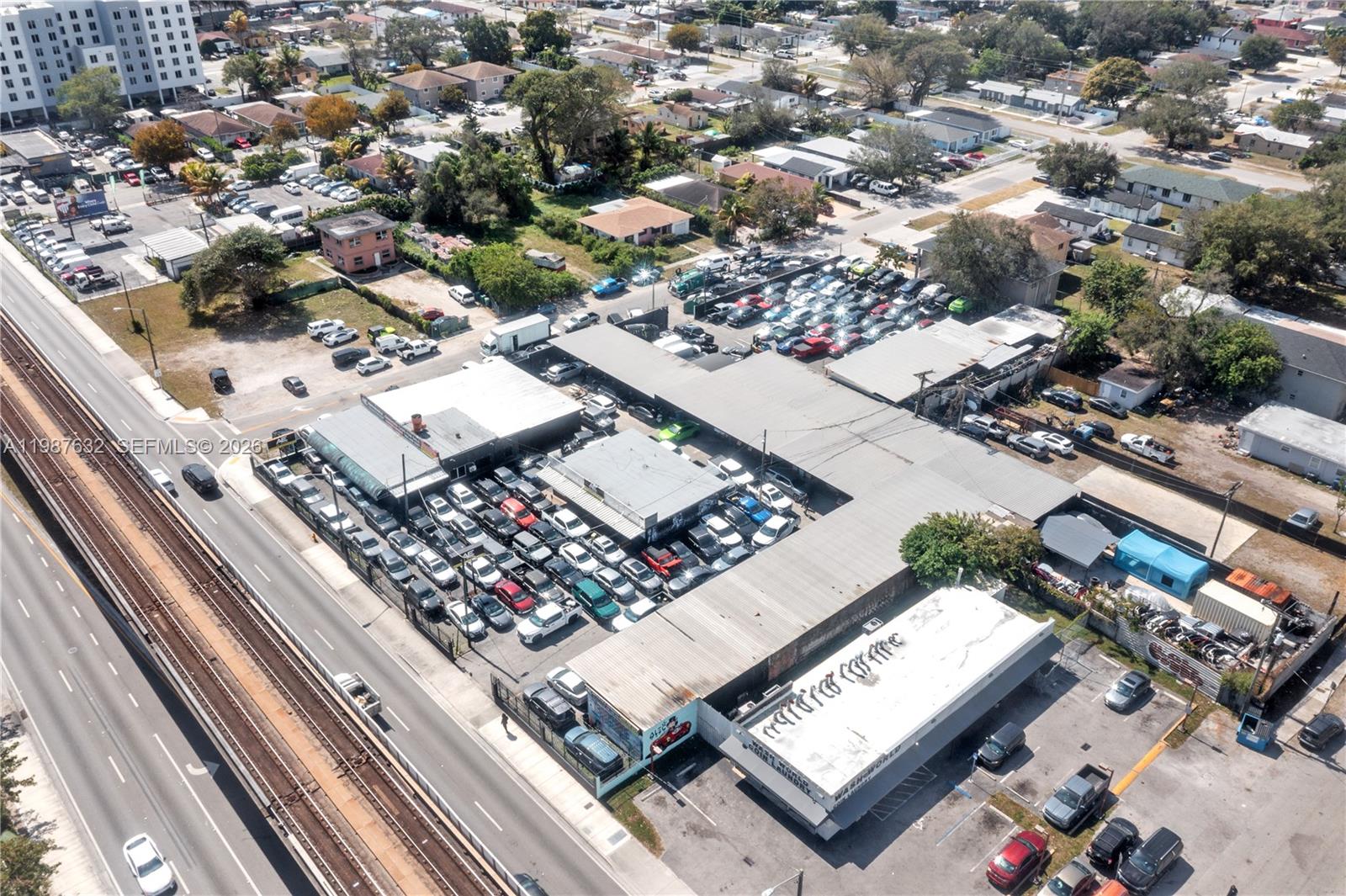An aerial view shows a commercial property with a large parking lot filled with cars — 5700 NW 27th Ave, Miami FL 33142, MIAMI, FL