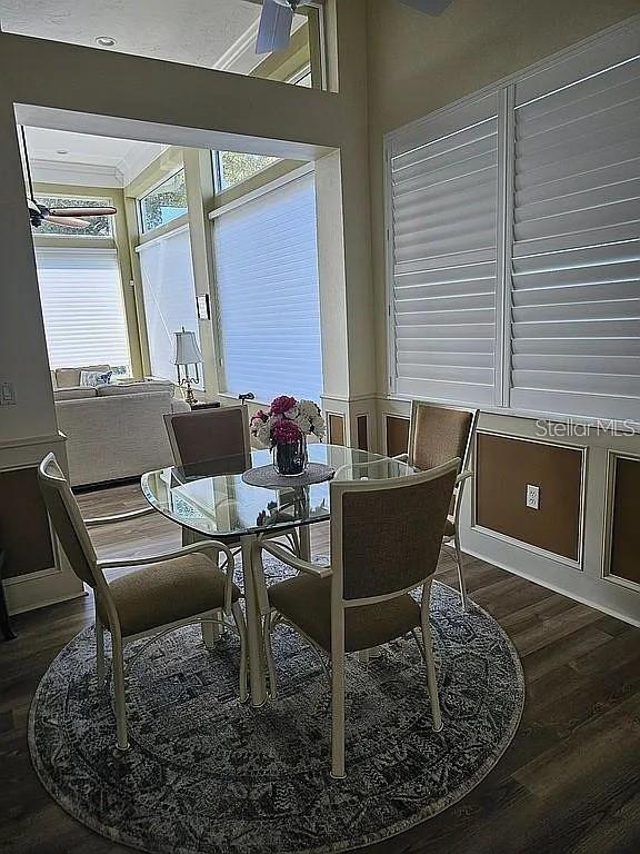 A dining area features a glass table, four chairs, and large windows with white shutters — 618 CROSSFIELD CIRCLE, VENICE, FL