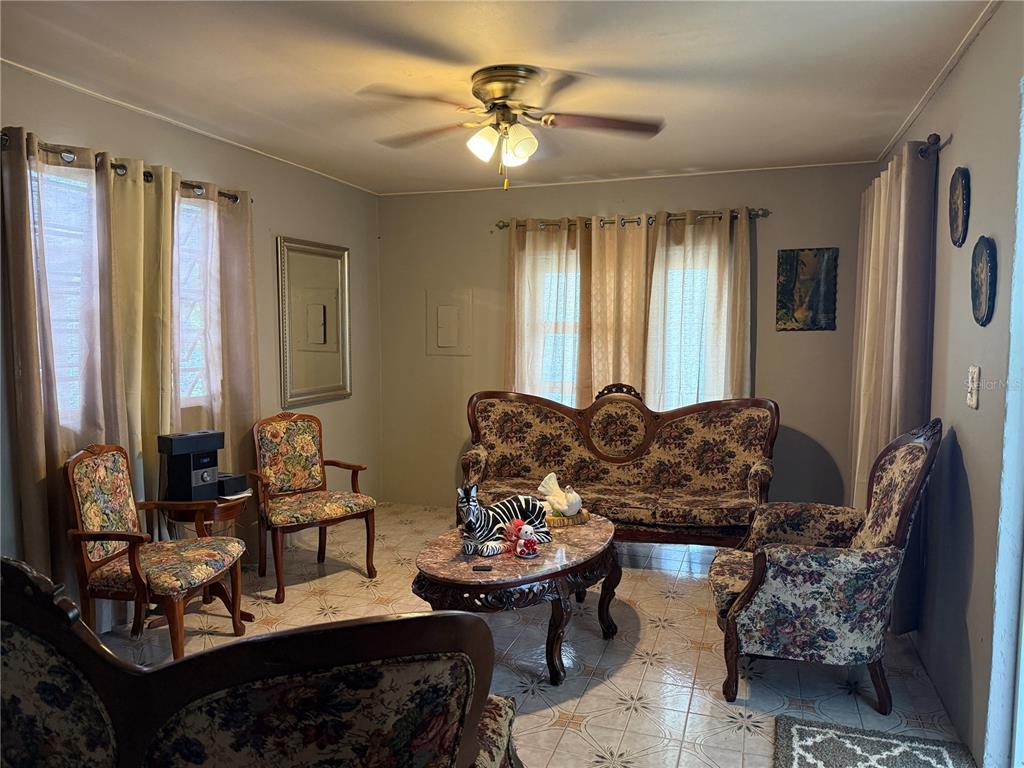 A living room features floral upholstered furniture, a marble-topped coffee table, and tiled flooring — 276 ROSA SANCHEZ, YABUCOA, PR