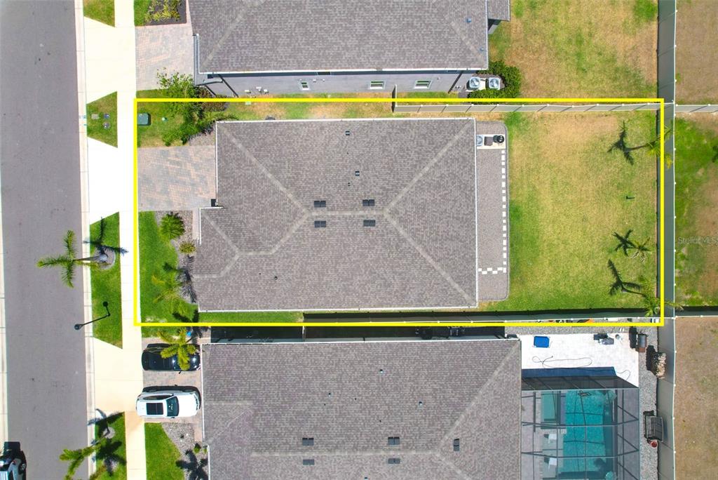 An aerial view shows a single-family home with a fenced backyard and a paved driveway — 3078 MARINE GRASS DRIVE, WIMAUMA, FL