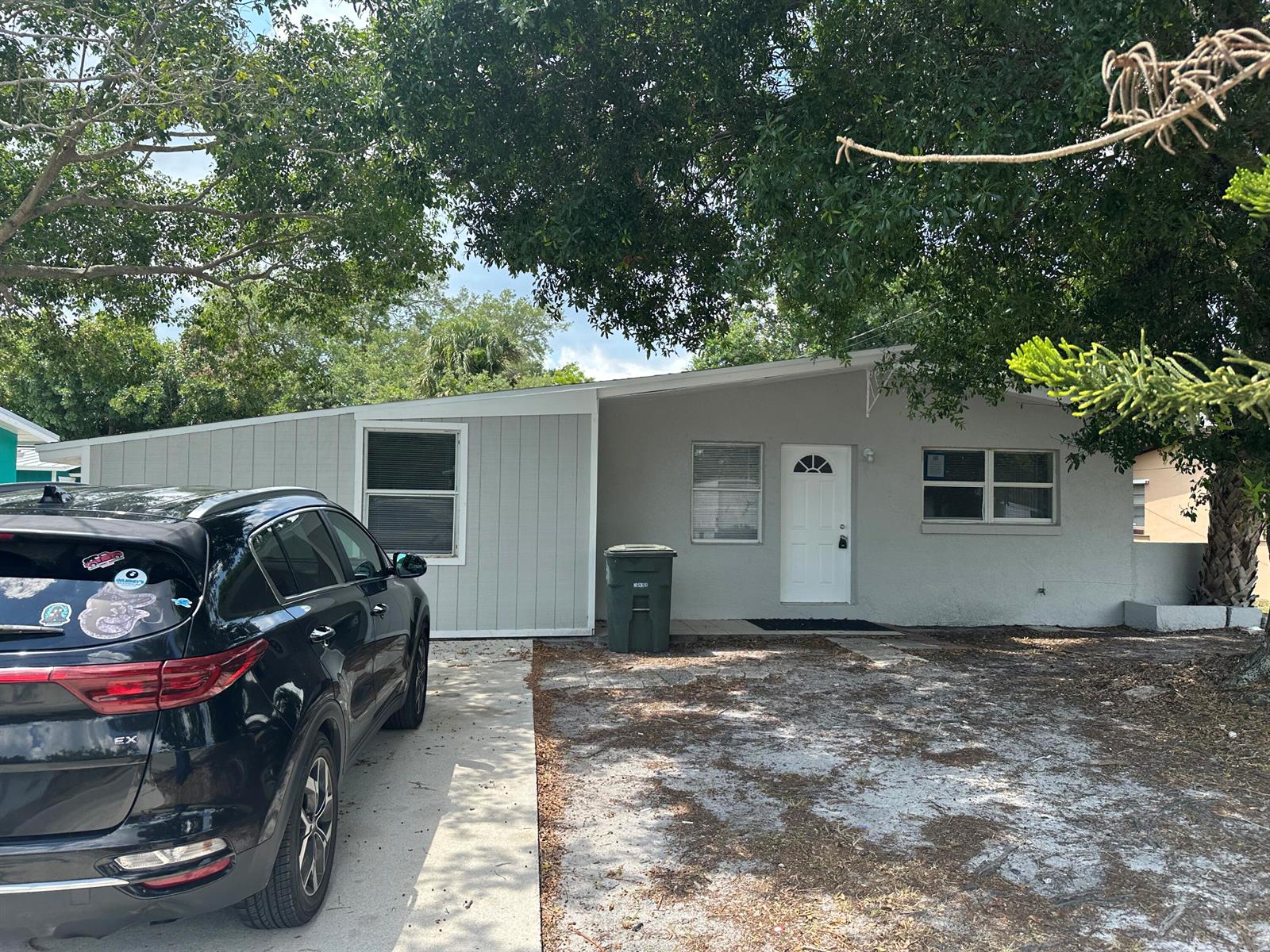 A single-story house with gray siding, a white front door, and a black car parked outside — 115 Maple Avenue, Fort Pierce FL 34982, FORT PIERCE, FL