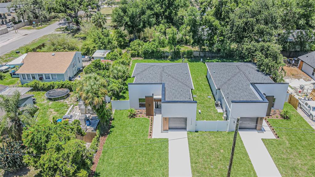 An aerial view shows two modern, flat-roofed houses with attached garages and green lawns — 12680 N CENTRAL AVENUE, TAMPA, FL