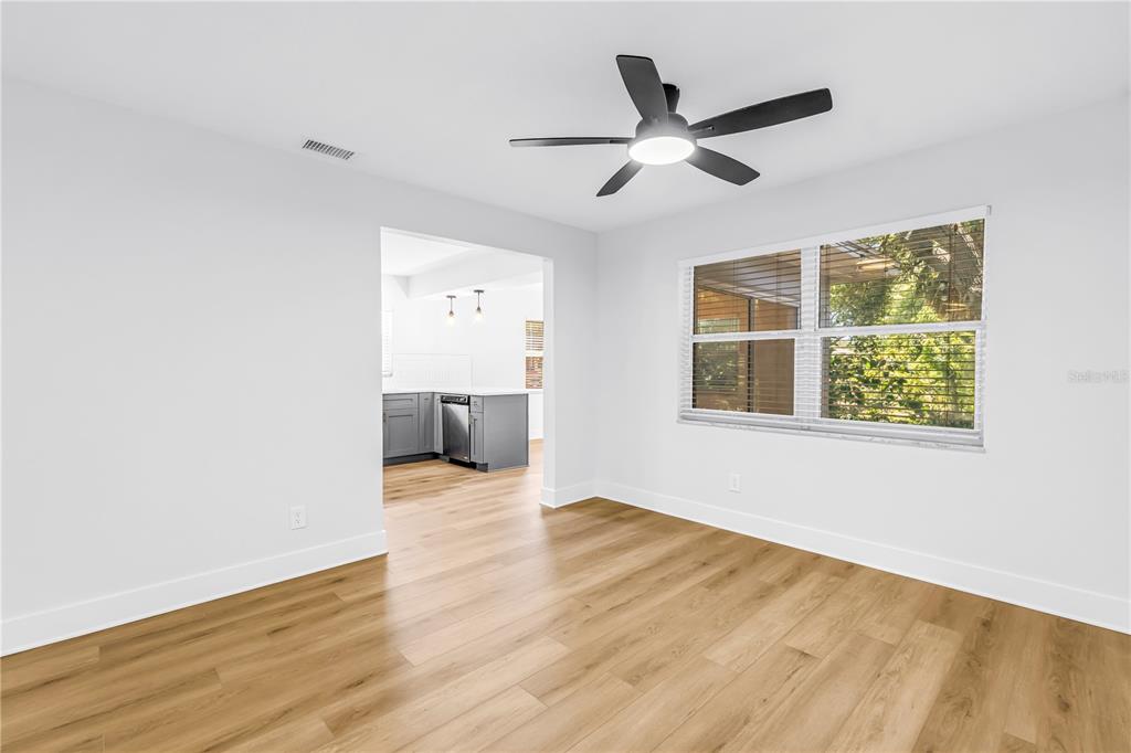 A bright room with light wood-look flooring, white walls, and a ceiling fan — 5846 12TH STREET S, ST PETERSBURG, FL