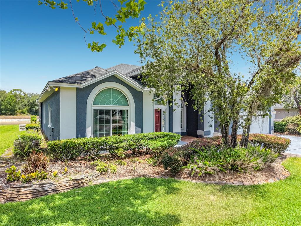 A swimming pool with a screen enclosure overlooks a lake during a vibrant sunset — 1104 NEEDLEWOOD LOOP, OVIEDO, FL