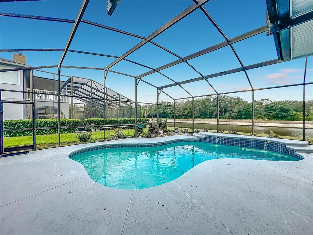 A single-story house with a dark blue exterior, arched window, and a landscaped front yard — 1104 NEEDLEWOOD LOOP, OVIEDO, FL