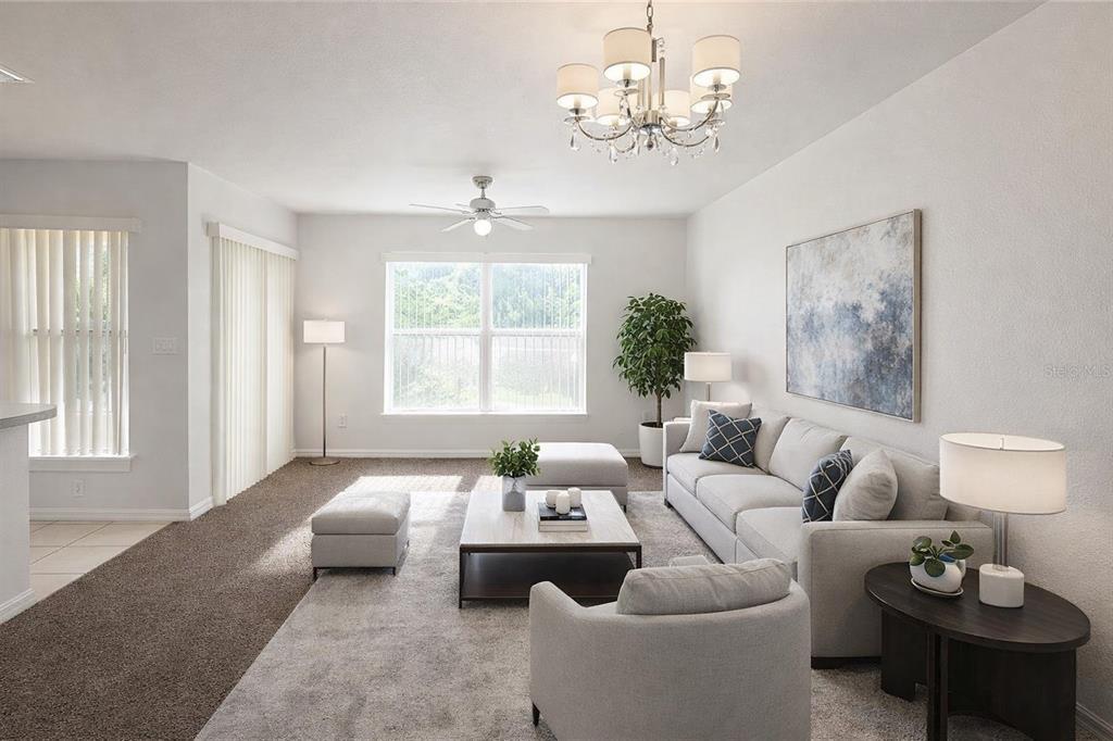 A living room features a light gray sofa, a coffee table, and a crystal chandelier — 2836 CLUB CORTILE CIRCLE, KISSIMMEE, FL