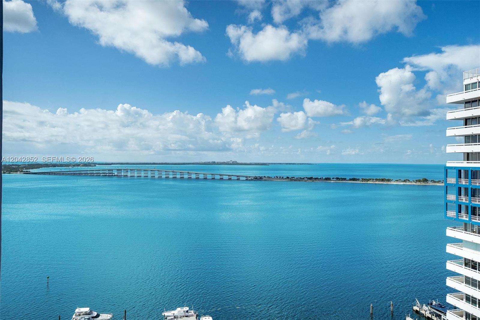 An elevated view of a blue bay with a long bridge and a nearby building — 1581 Brickell Ave # 1805, Miami FL 33129, MIAMI, FL