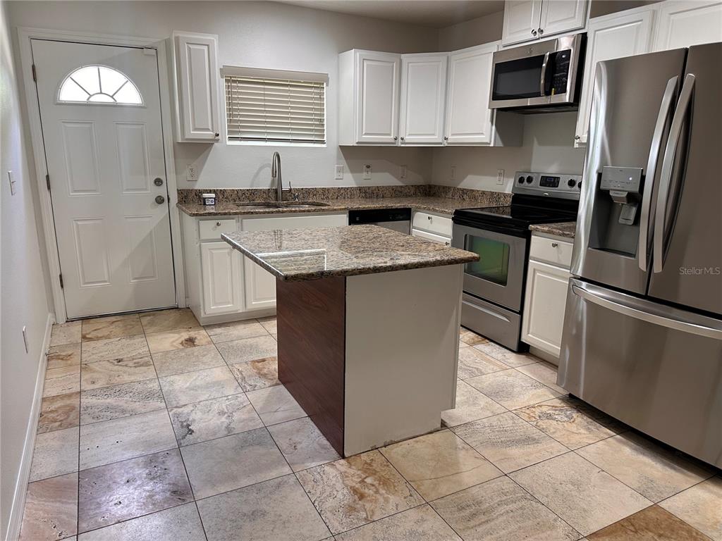 A kitchen features white cabinets, granite countertops, stainless steel appliances, and a central island — 809 W HIAWATHA STREET, TAMPA, FL
