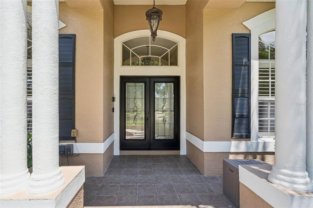A single-story house with a large front lawn, a prominent tree, and a paved driveway — 2230 RIDGEWIND WAY, WINDERMERE, FL