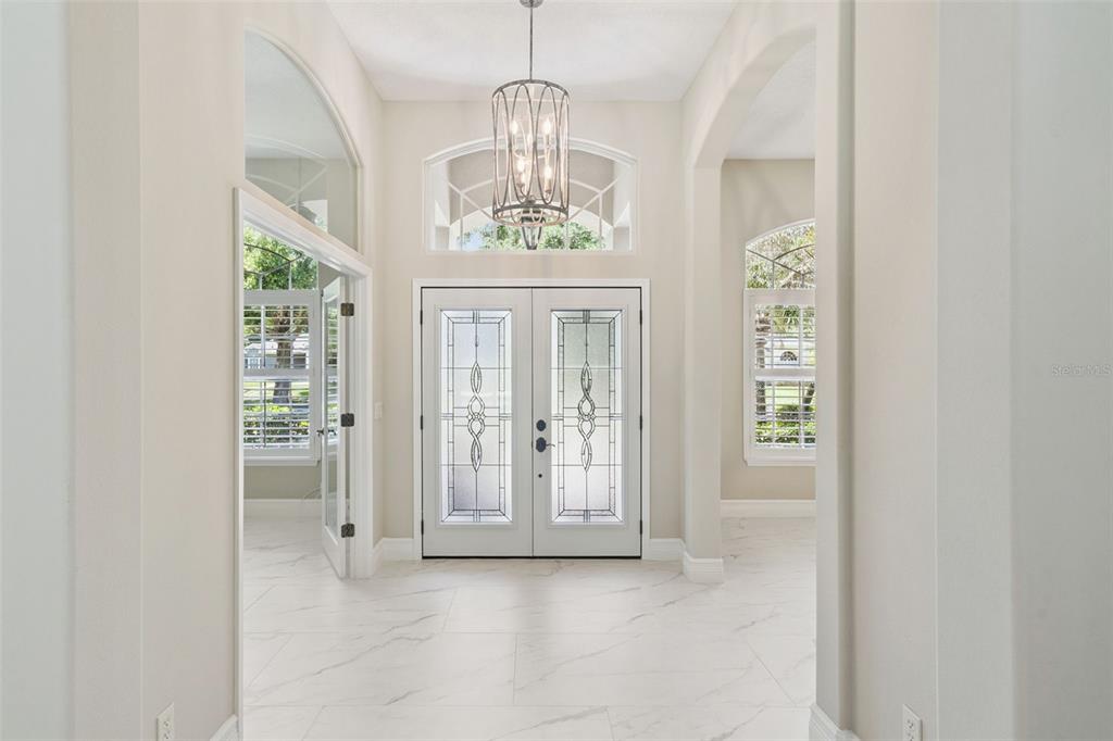 A front entryway features double glass doors, a transom window, and two white columns — 2230 RIDGEWIND WAY, WINDERMERE, FL